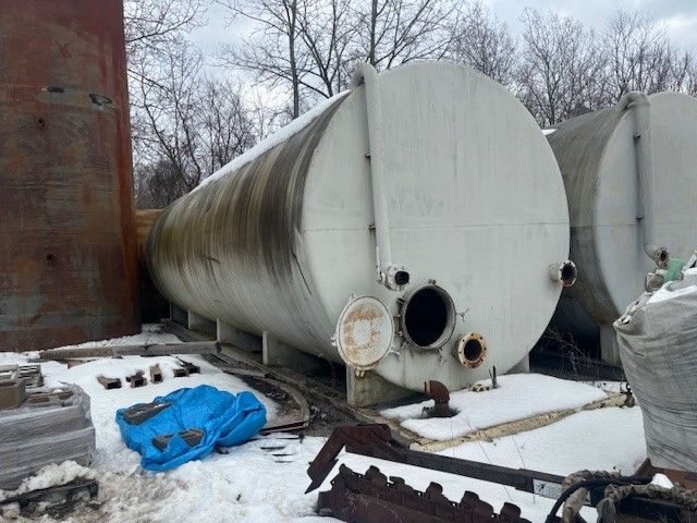 A large white tank is sitting in the snow.