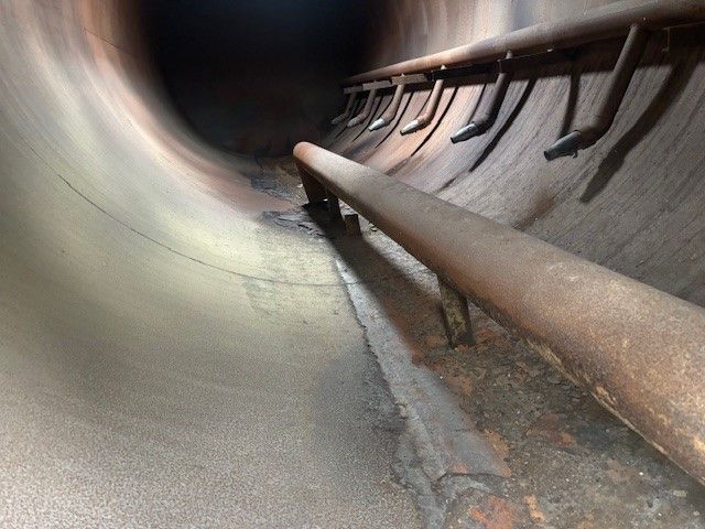 A close up of a metal pipe in a tunnel.