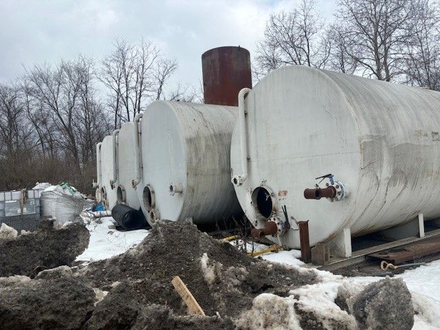 A row of large white tanks are sitting in the snow.