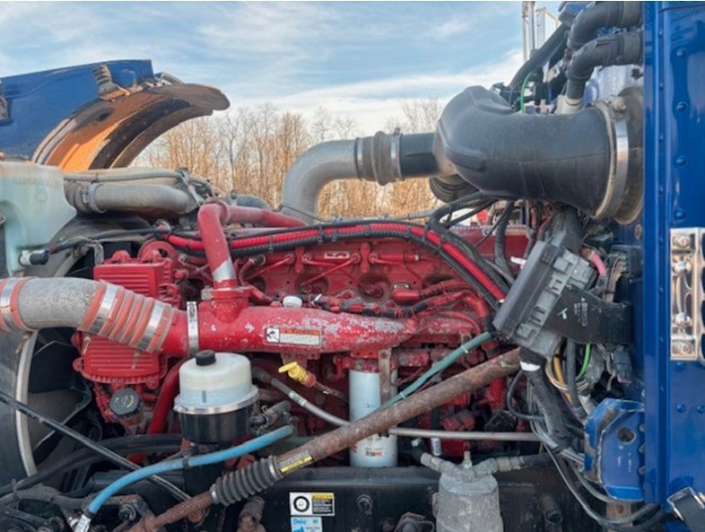 A blue vacuum truck is parked on the side of the road