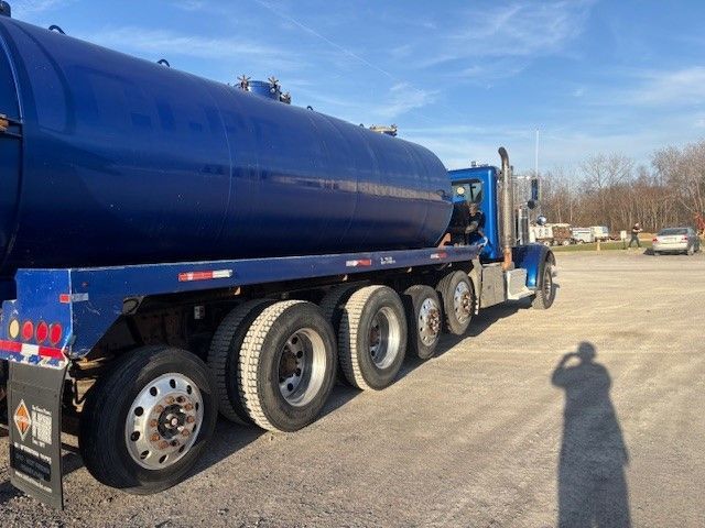 A blue semi truck is parked in a parking lot.