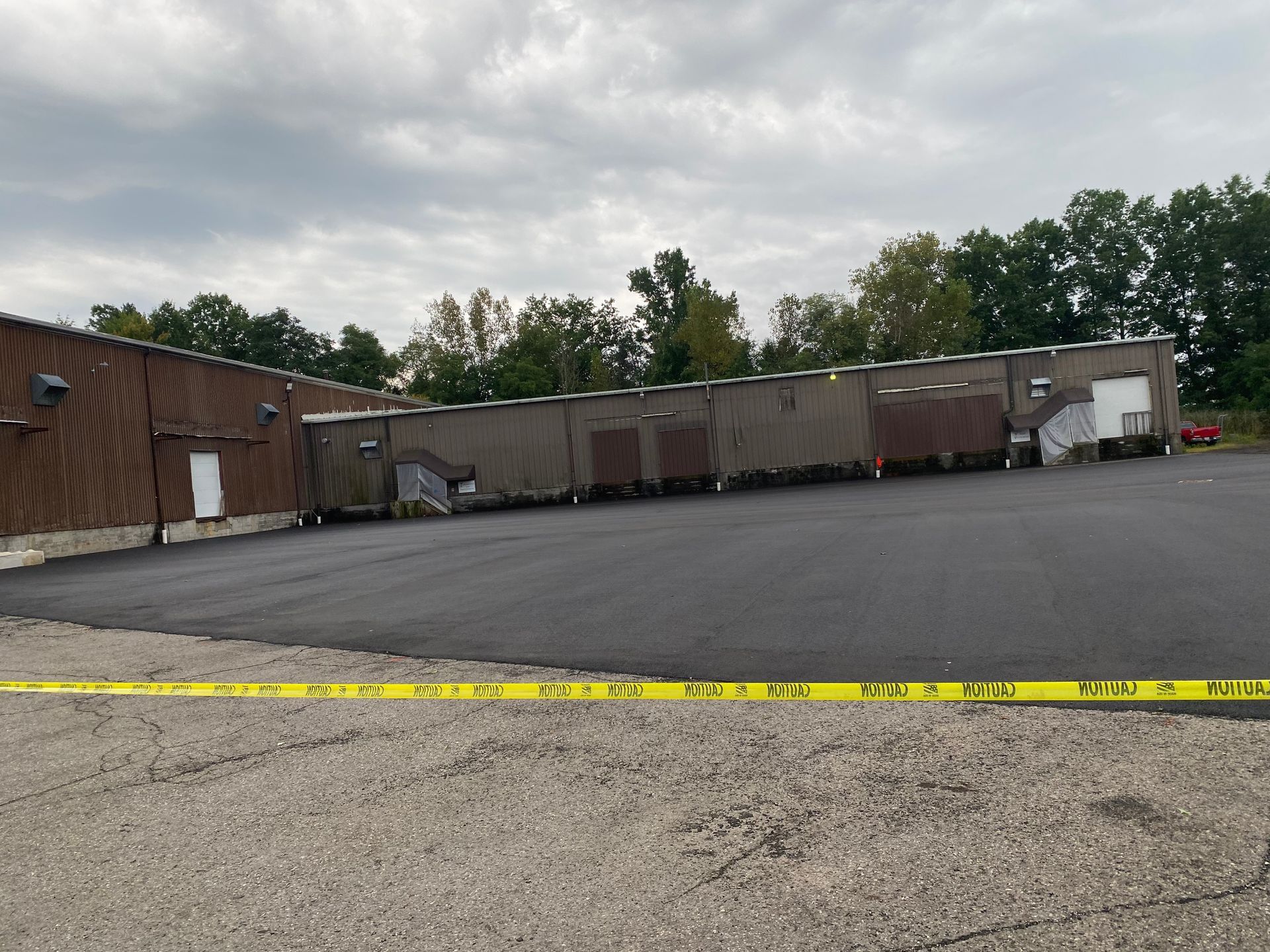 A large parking lot with a building in the background and a yellow tape.