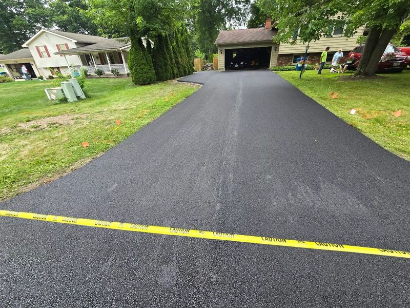 A driveway leading to a house with a yellow tape on it