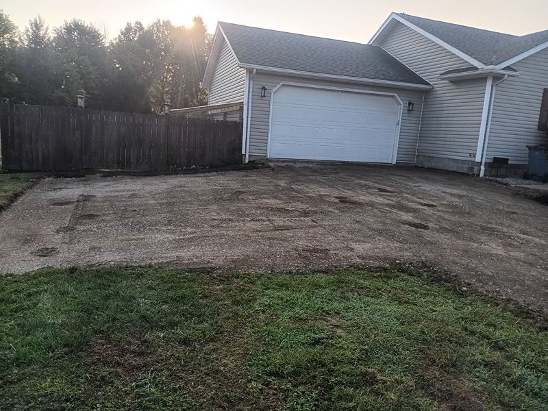 A house with a garage and a driveway in front of it.