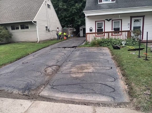 A driveway is being repaired in front of a house.