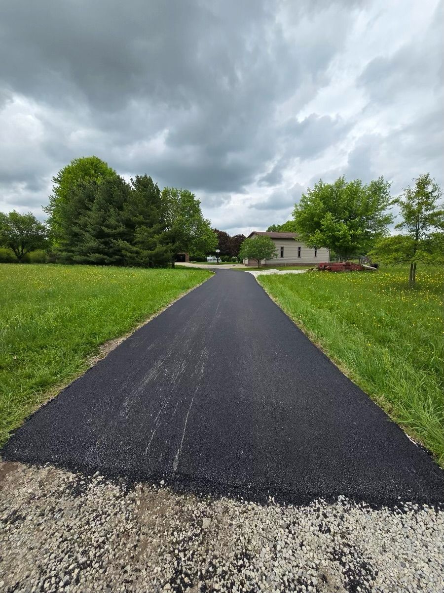 A road that is going through a grassy field.