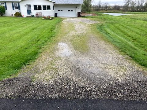 There is a gravel driveway leading to a house.
