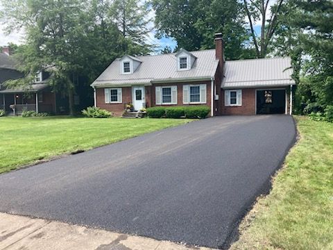 A brick house with a driveway leading to it.