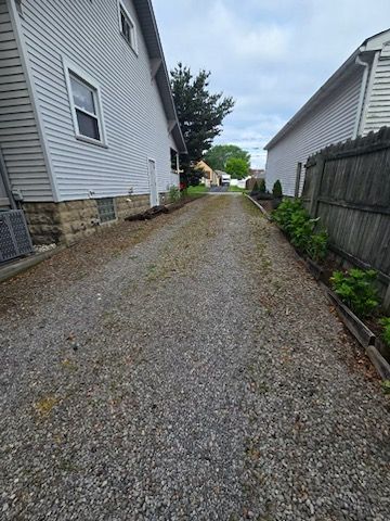There is a gravel driveway between two houses.