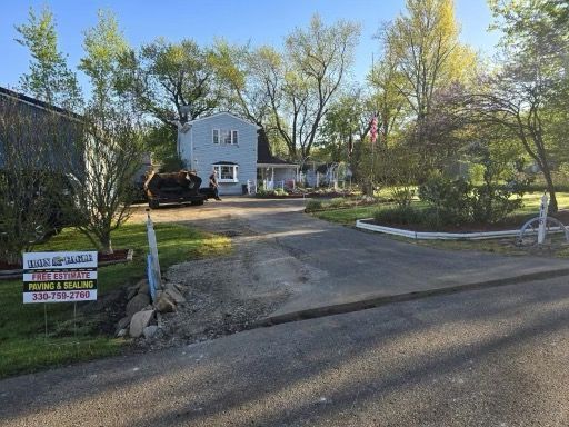 A large white house is sitting on top of a lush green hillside.