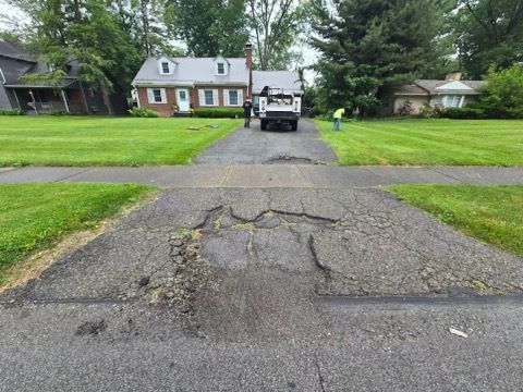 A truck is parked in a driveway next to a house.