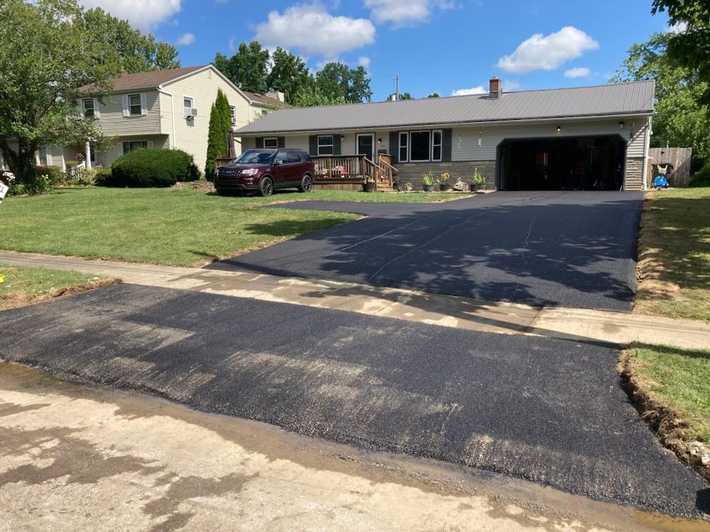 A car is parked in a driveway in front of a house.
