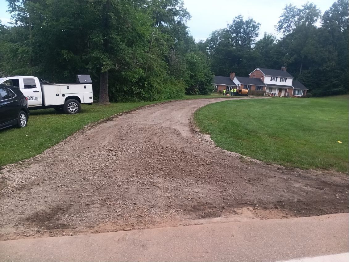 A white truck is parked on the side of a dirt road