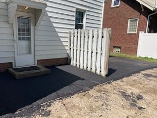 There is a white picket fence in front of a house.