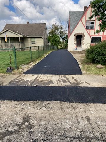 A driveway is being paved in front of a house.