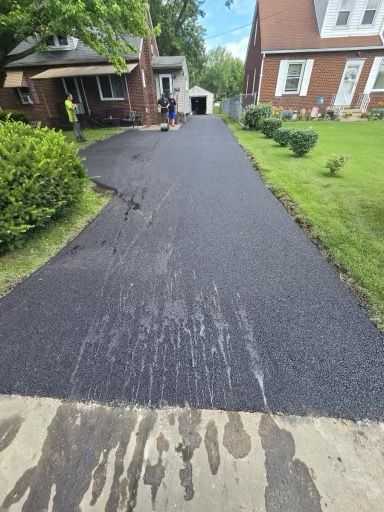 A driveway is being paved in front of a house.