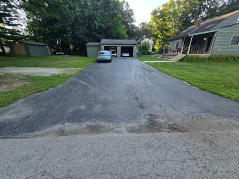 A car is parked in the driveway of a house.