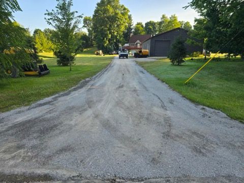 A dirt road with a house in the background