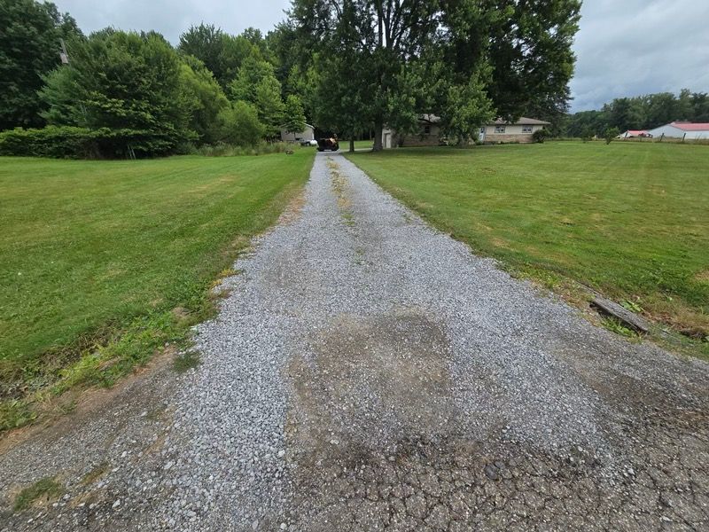 A gravel road going through a grassy field