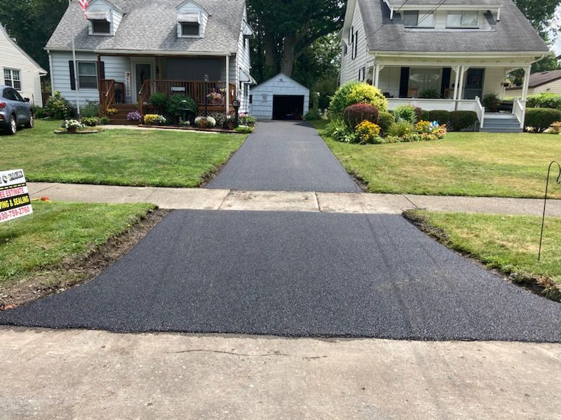 A driveway is being paved in front of a house.