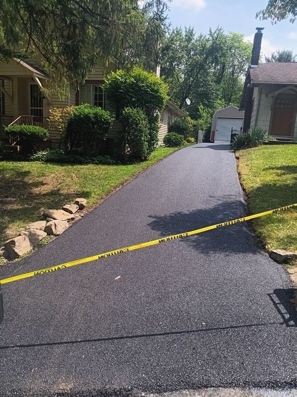 A driveway is being paved in front of a house.