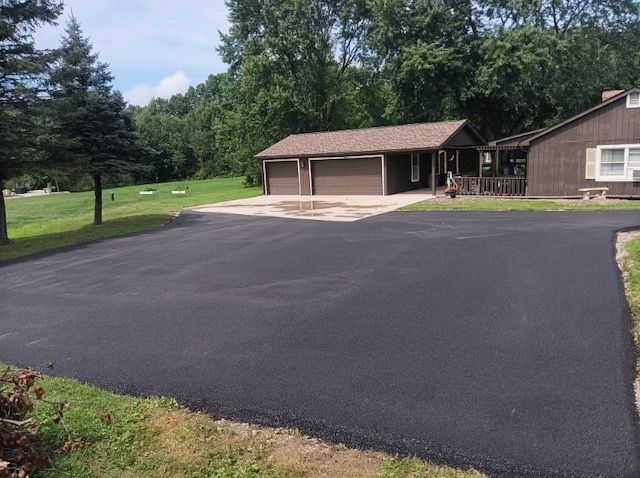 A house with a garage and a driveway in front of it.