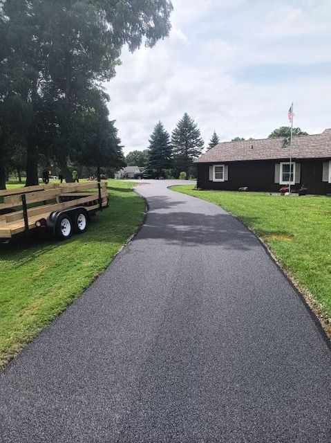A trailer is parked on the side of a road next to a house.
