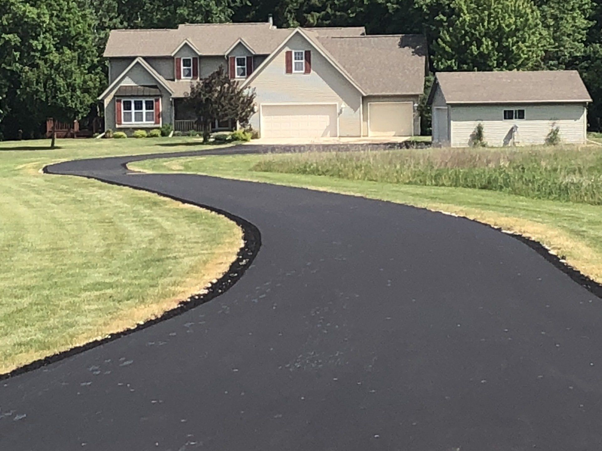 A large house with a curved driveway leading to it
