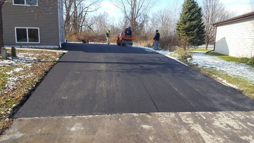 A driveway is being paved in front of a house