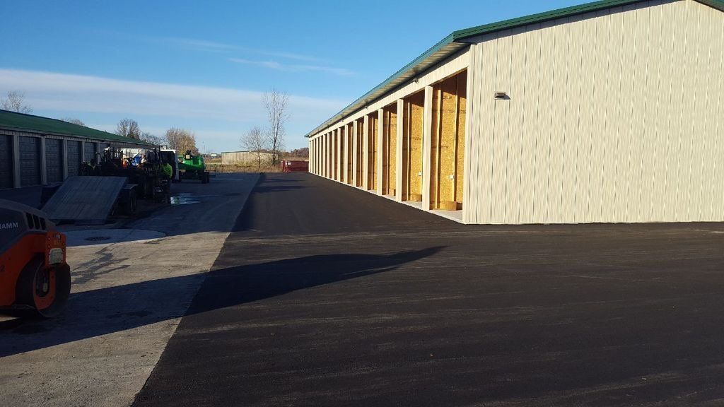 A row of storage units are lined up in a parking lot.