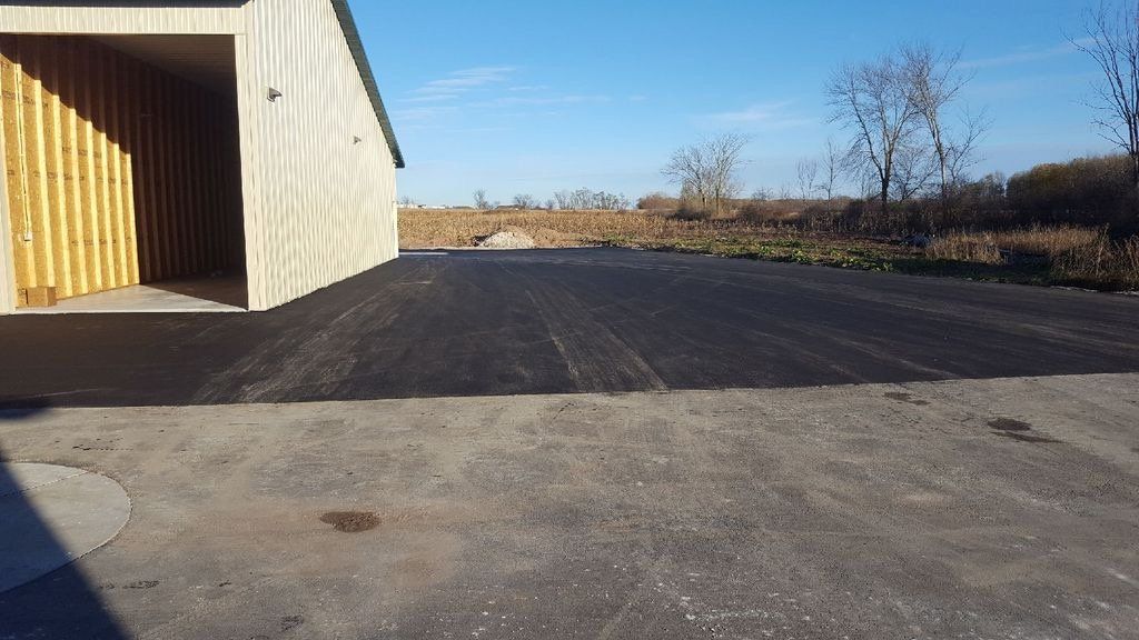 There is a garage in the background and a concrete driveway in the foreground.