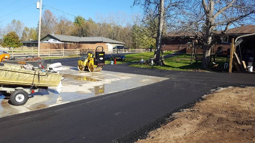A truck is parked on the side of a road next to a house.