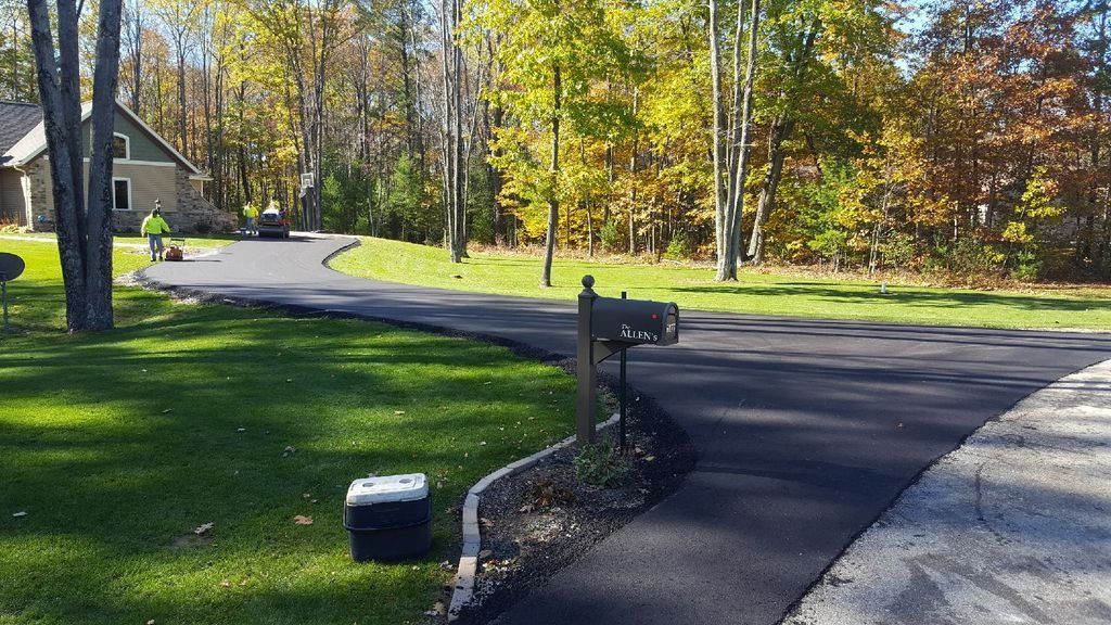 A cooler is sitting on the side of a road next to a mailbox.