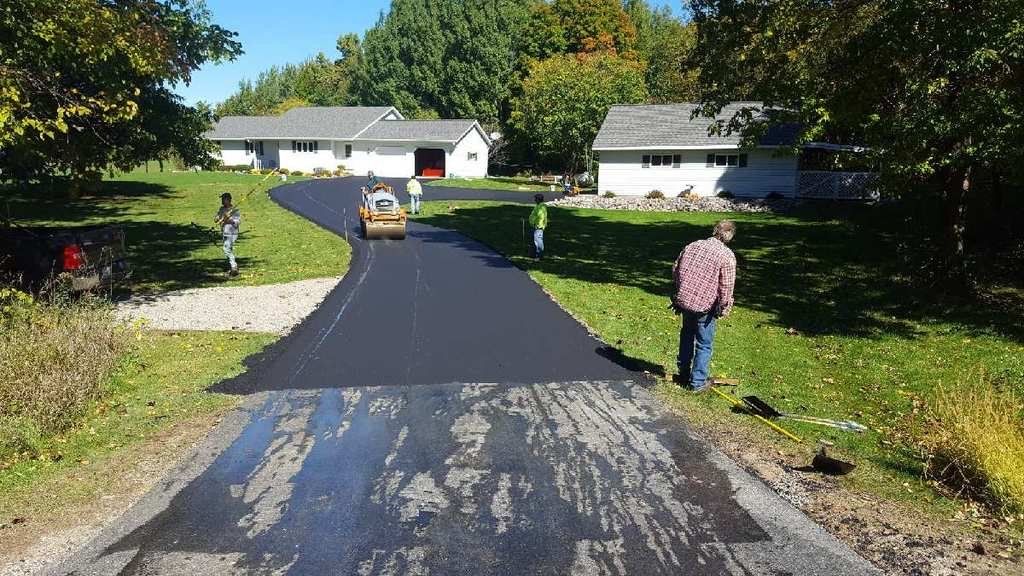 A man is walking down a road that is being paved.