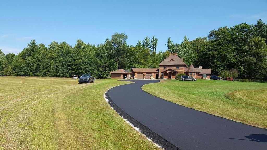 A car is parked on the side of the road in front of a house.