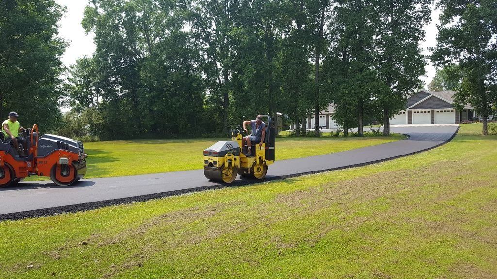 A couple of tractors are driving down a road.