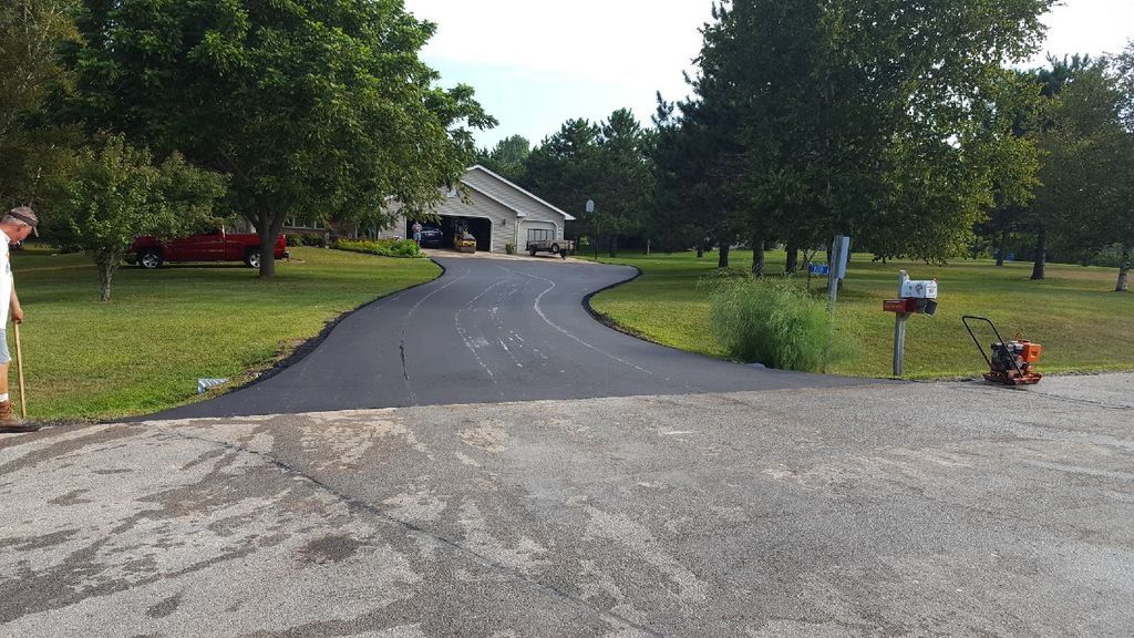 A driveway with a mailbox on the side of it