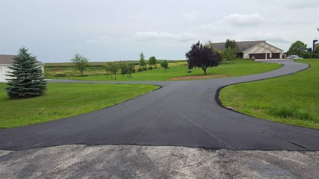 A curvy driveway leading to a house in the distance