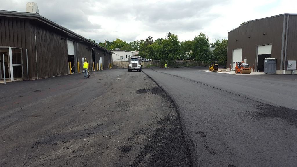 A truck is driving down a road in front of a building