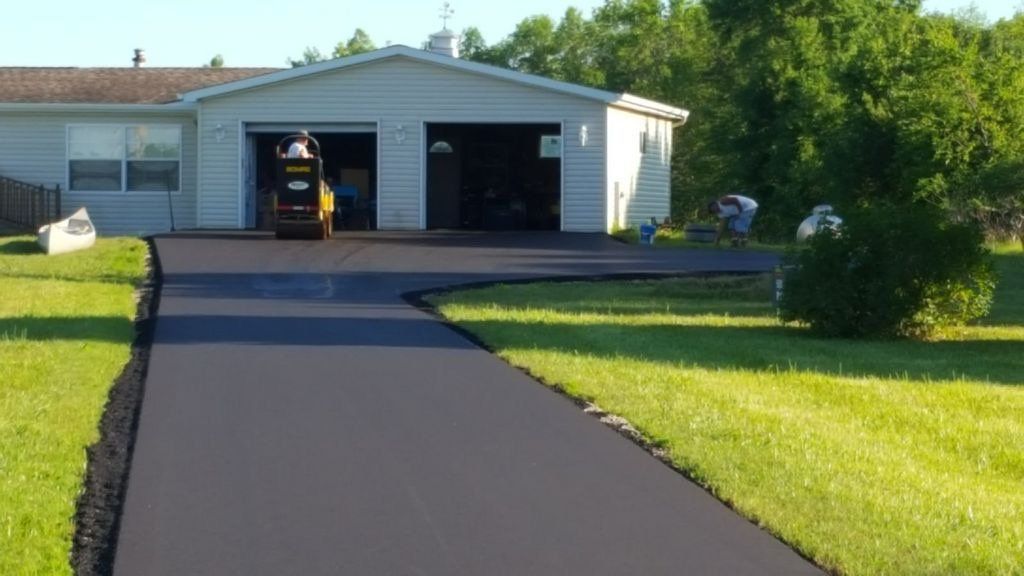 A driveway is being paved in front of a house.