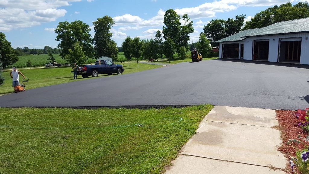 A truck is parked in a driveway next to a house
