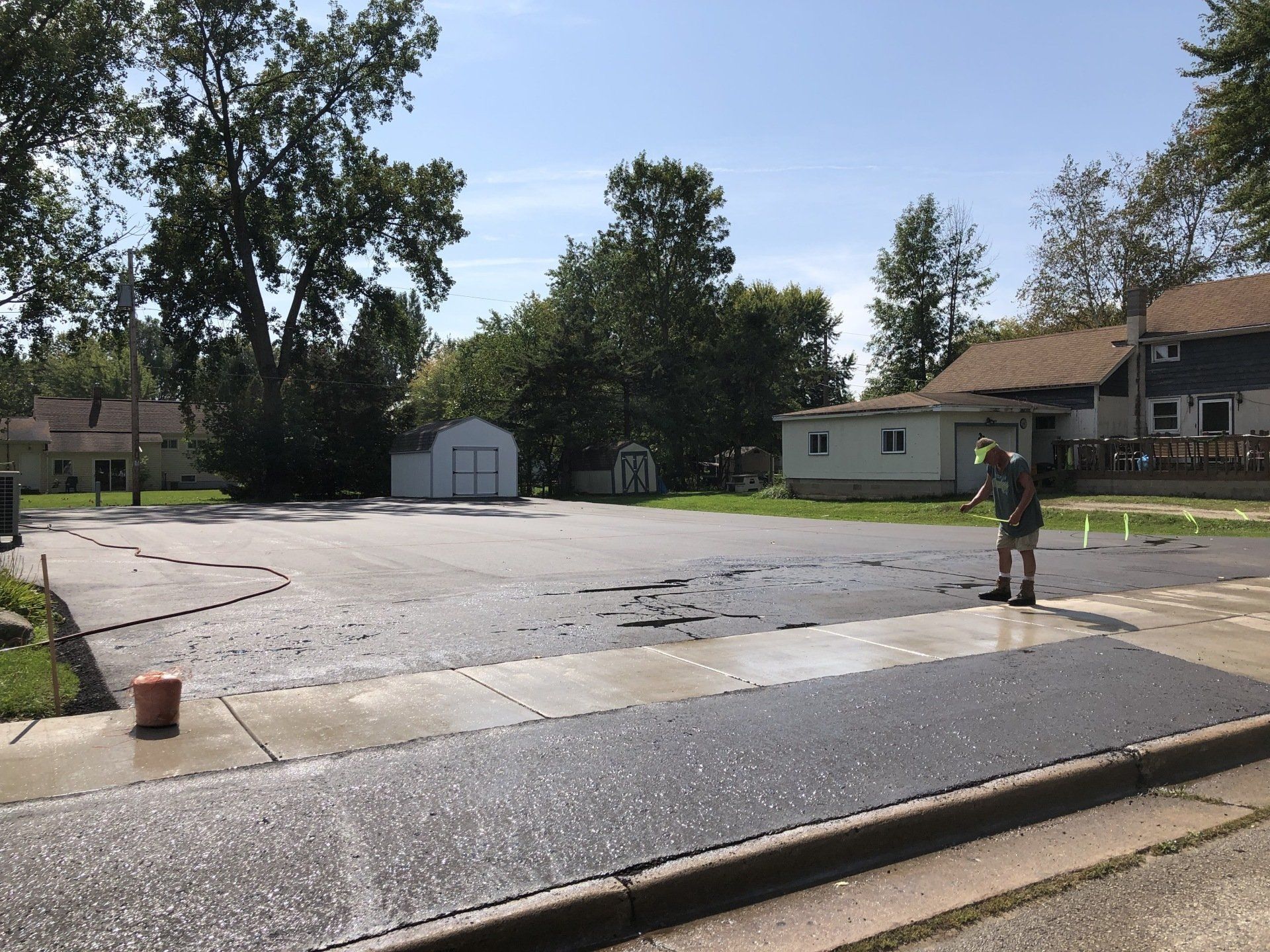 A man is standing in the middle of a parking lot.
