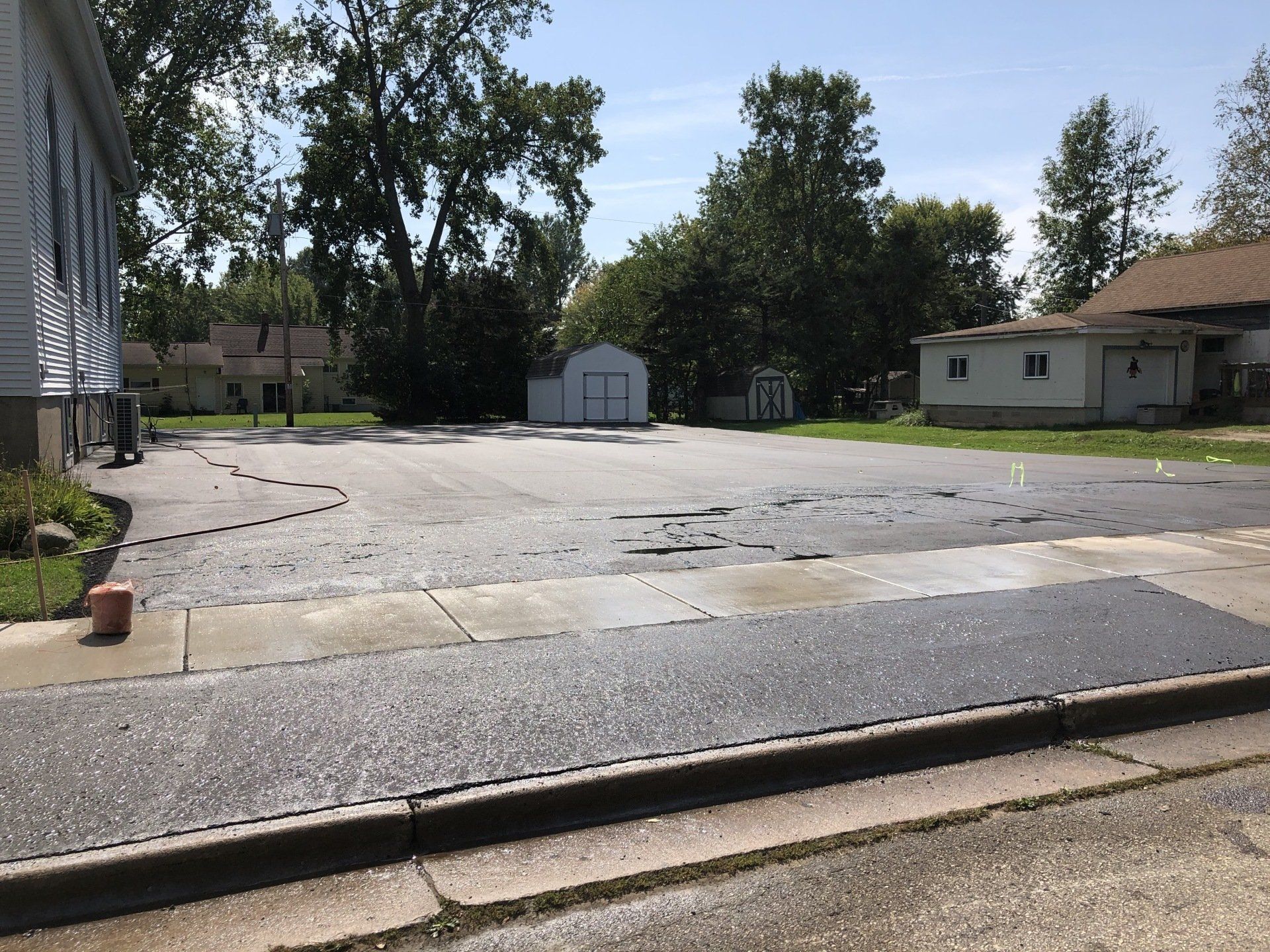 An empty parking lot with a house in the background
