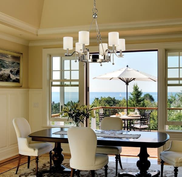 A dining room with a table and chairs and a view of the ocean