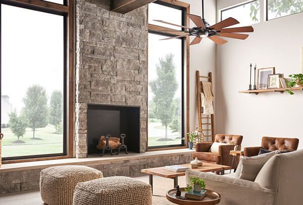 A living room with a fireplace and a ceiling fan.