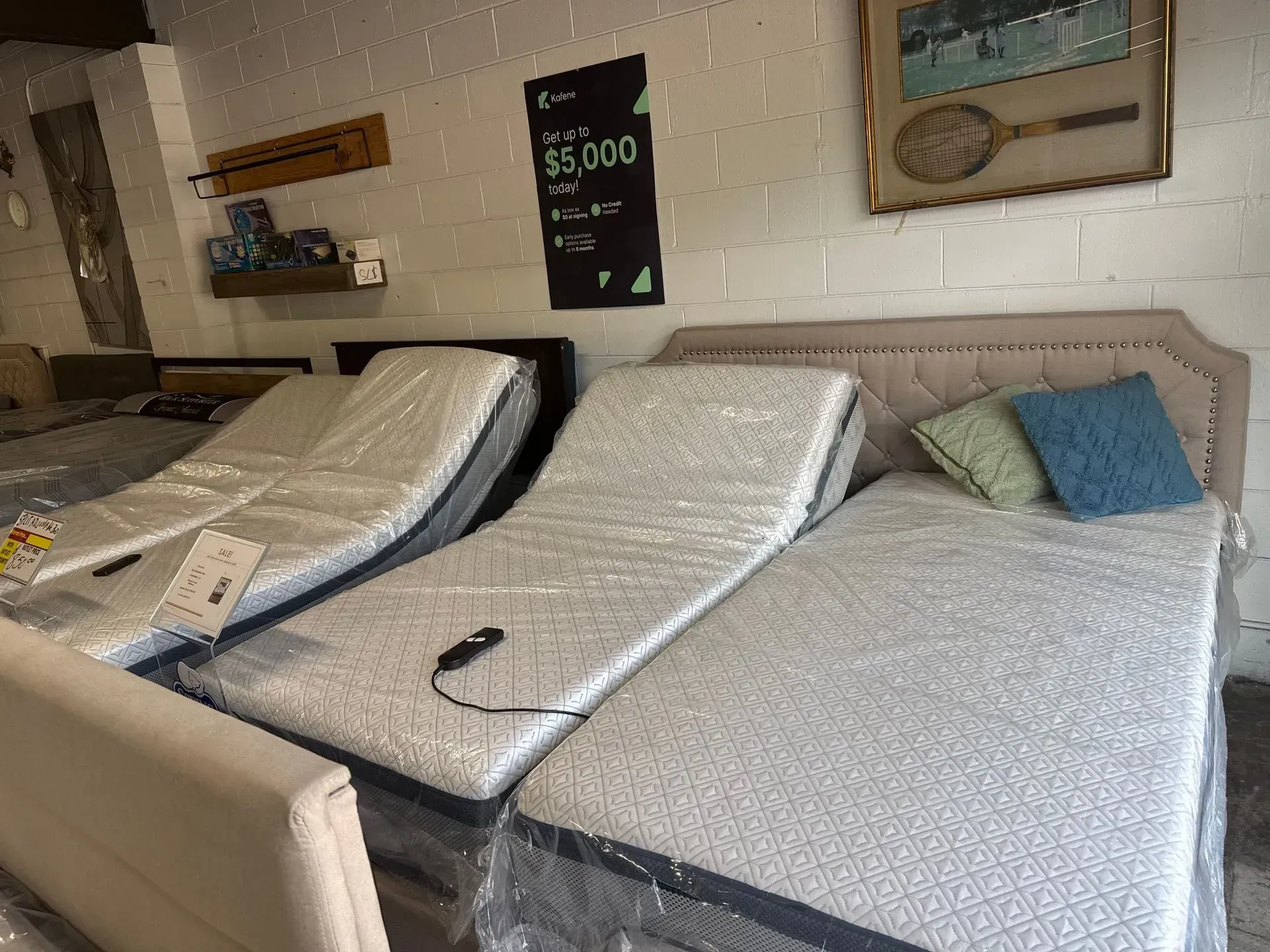 Beds in a showroom; adjustable mattresses and a bed with pillows.