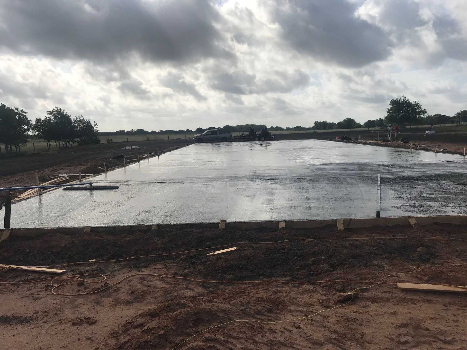 Newly poured concrete slab; overcast sky above a construction site.
