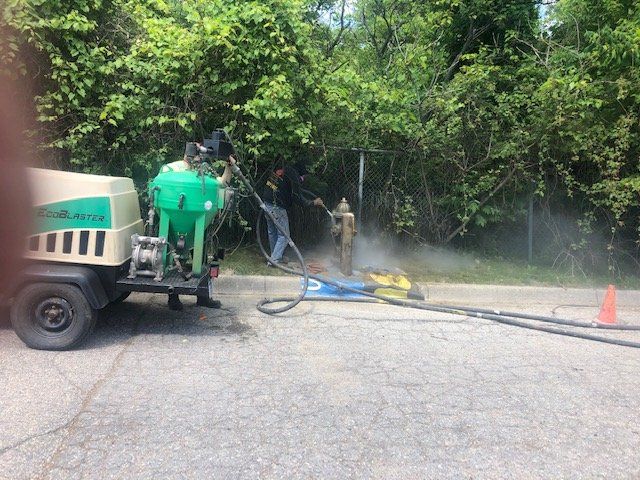 A man is working on a fire hydrant with a hose attached to a trailer.