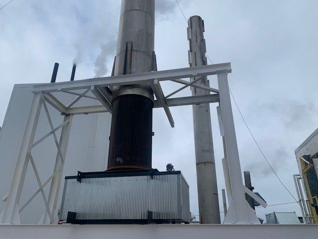 A factory with smoke coming out of the chimneys