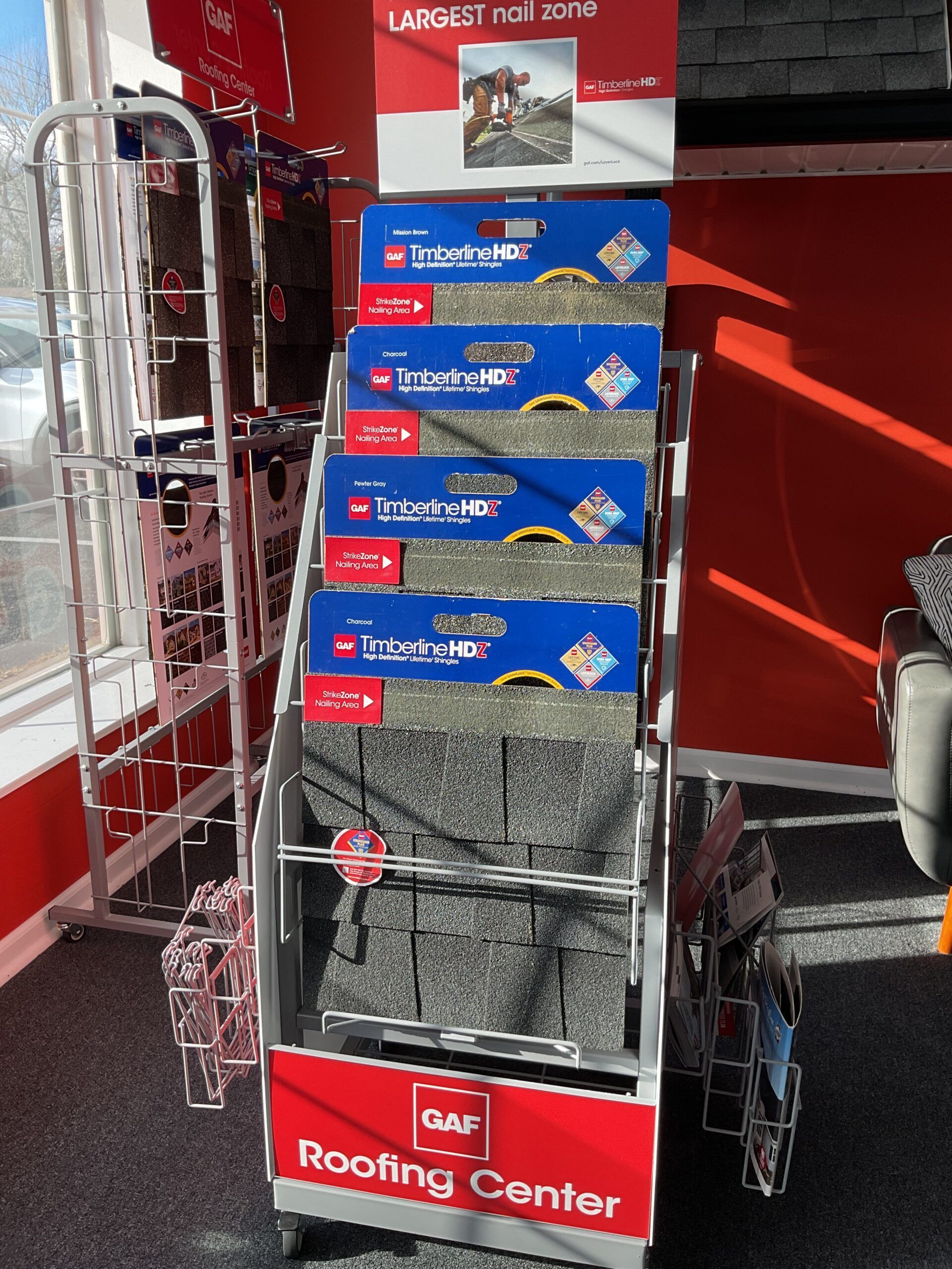 Red roofing center cart stacked with boxed shingles in a store aisle